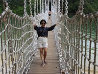Fruen på gyngende bro. Broen går fra Sentosa til Palawan Island.
